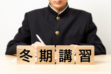 「冬期講習」と書かれたブロックと男子学生