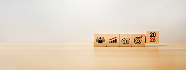 Wooden blocks showing business team, financial growth, money savings, and target icons with the year 2026, representing future planning, financial goals, economic growth strategies, long-term