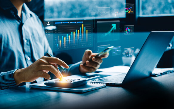 Business professional reviewing digital financial dashboards and real-time analytics using smartphone, laptop, and calculator to evaluate performance metrics and support strategic decision-making. - Powered by Adobe