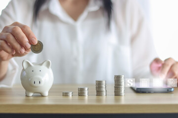 women hand holding coin in to white piggy bank for use to business and money concept