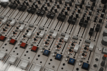 Vintage wooden audio mixing console with knobs, sliders, and buttons.