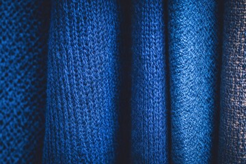 Textiles in various blue shades arranged neatly for display in a fabric store during daylight hours