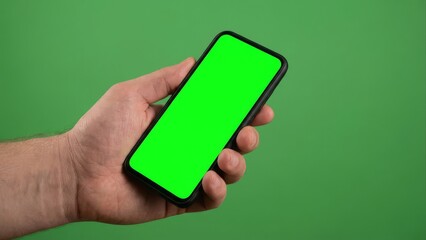 Hand holding a modern smartphone with a green screen display