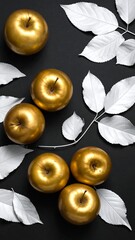 Overhead composition of five shiny golden apples with subtle stems scattered among bright white leaves on a dark backdrop