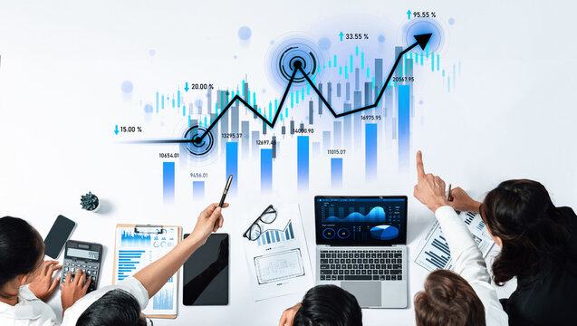 A diverse business team collaborates in a modern office setting, analyzing financial data with charts and laptops, aiming for strategic growth and solutions. Scalp - Powered by Adobe