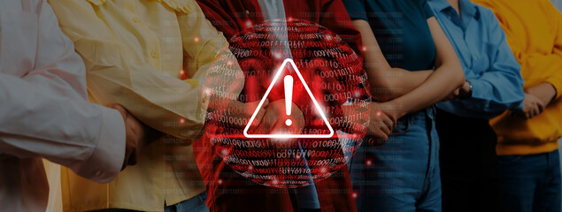 A diverse group of individuals stands united with crossed arms, conveying a sense of caution or alertness, enhanced by digital effects and a striking warning symbol. Gantry