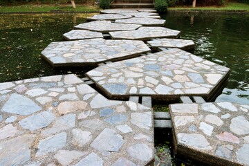 Terrazzo stone bridge crossing pond in a park