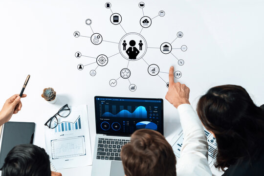 A business team collaborates on data analysis and strategy planning, utilizing a digital display and a whiteboard to visualize information and drive decisions. Trope - Powered by Adobe