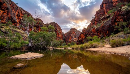 Scenic canyon landscape with rugged red rock cliffs reflecting in calm water pool at sunset. Nature concept