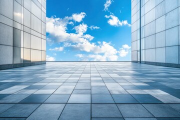 A spacious, modern building with a large glass facade and a curved roof, set against a backdrop of a clear blue sky with fluffy white clouds.