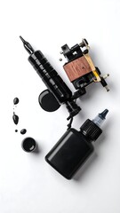 Overhead shot of tattoo machine and ink bottle alongside ink puddles, creating an art studio setup. The background is white