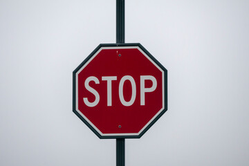Stop sign against white overcast sky