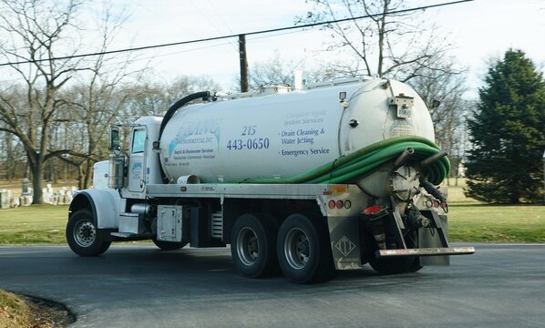 Sellersville, Pennsylvania, U.S - Dec 13, 2025 - The septic service truck from Franc Environmental Inc., providing wastewater management, turning on the road near a cemetery.