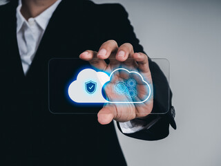 Businessman holding futuristic glass phone with cloud security symbol and data processing icons on screen, representing cloud computing, cybersecurity, and digital data protection technology.