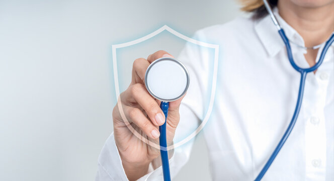 Annual health checkup concept with female doctor using diagnosis stethoscope with shield icon for preventive screening. Early detection and risk assessment for future diseases and treatment planning.