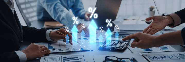 A group of business professionals work together in a modern office environment, focusing on financial growth strategies, utilizing digital analytics and charts. Trope