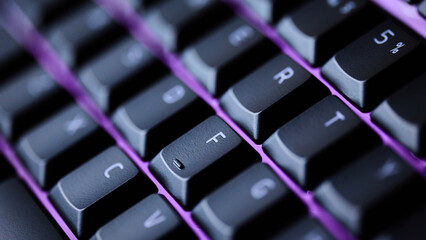 Macro shot of mechanical keyboard keys with purple RGB glow for gaming and streaming