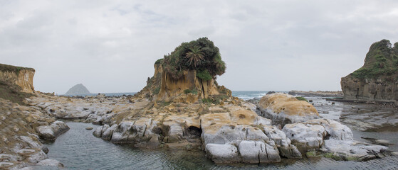 Panoramic view of the famous "Guardian Rock" and unique eroded sphinx or lion shaped rock sandstone formations along the coastline in Heping Island Park, Keelung, Taiwan.