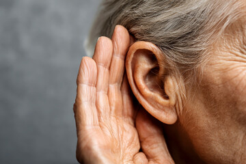 Senior woman trying to hear something on isolated background.