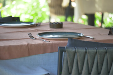 Fototapeta premium Dining table is set with plates and utensils for a meal
