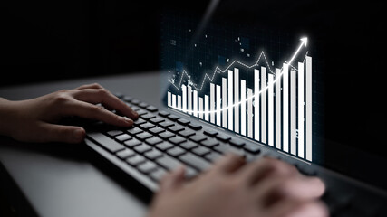 Modern hands typing on a sleek keyboard, with a dynamic data graph projection showcasing growth and financial analysis, illustrating digital work environments and insights. Impute