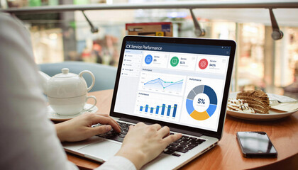 Business professional working on laptop displaying service performance metrics in cafe, showcasing data analysis and productivity