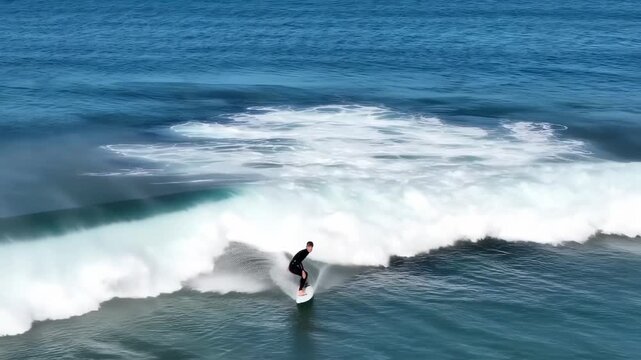 A surfer carves a wave, cresting and riding through the water