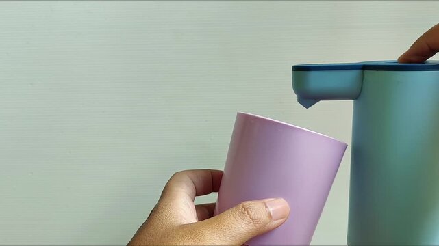 Footage of a person taking drinking water from a gallon pump, suitable for daily life, hygiene, household, clean water, refill station, and healthy lifestyle content.