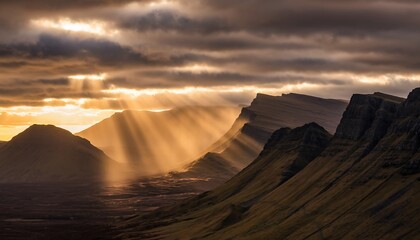 Dramatic Sun Rays Over Rugged Mountain Landscape at Sunset.