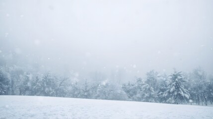 Snowflakes gently falling on a serene winter landscape with snow-covered trees in the distance