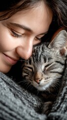 Woman cuddling with her sleeping cat in cozy indoor setting, vertical photo