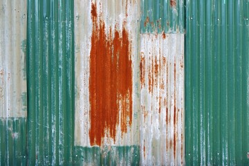 Green corrugated metal sheets wall paint peeling off and rusted background