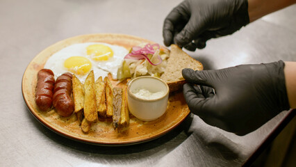 Preparing food. Restaurant culinary. Chef hand in glove adding sliced bread to served hot dish....