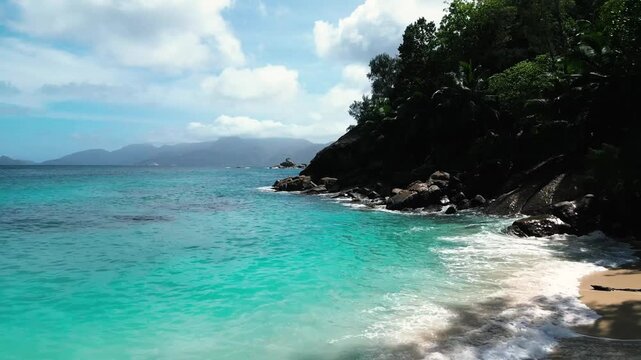 Beach in Mahe - Seychelles, drone flight white sand beach, rocks and the turkis ocean