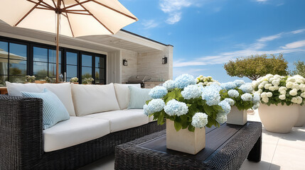 Outdoor patio with natural wicker sofa, white cushion, blue hydrangea, potted plant, umbrella, sunny sky, modern home