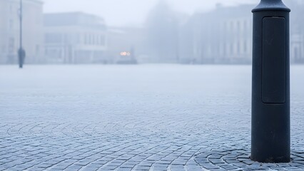霧の広場に立つ黒いボラード