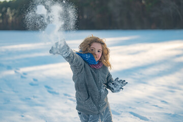 Excited kid playing snowball. Winter outdoor playtime kid. Cute kids snowball fight in winter. Excited child tossing snowball outdoors. Active winter child portrait. Amazed child in snowball action.