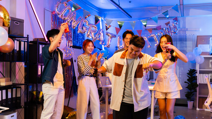 Asian business team celebrating New Year 2026 or major milestone achievement in office party,holding large 2026 foil number balloons and confetti falling.Concept of corporate success,festive teamwork 