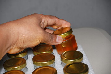 Close-up of mini hexagonal glass jars with pure honey and gold lids for wedding favors and event souvenirs