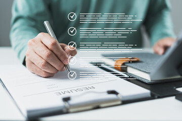 Pen marking printed checklist with resume layout