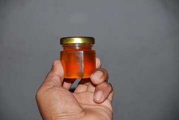Close-up of mini hexagonal glass jars with pure honey and gold lids for wedding favors and event souvenirs