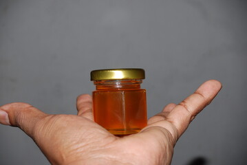 Close-up of mini hexagonal glass jars with pure honey and gold lids for wedding favors and event souvenirs
