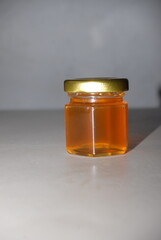 Close-up of mini hexagonal glass jars with pure honey and gold lids for wedding favors and event souvenirs