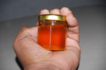 Close-up of mini hexagonal glass jars with pure honey and gold lids for wedding favors and event souvenirs