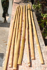 Artisanal process of covering door windows with natural bamboo sticks using basic hand tools and safety gloves