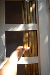 Artisanal process of covering door windows with natural bamboo sticks using basic hand tools and safety gloves