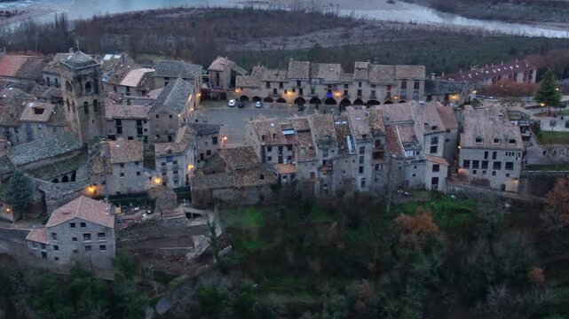Aerial view of the medieval town of Ainsa in Huesca, Spain, with illuminated historic buildings