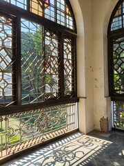 Historic Balcony with Leaded Glass Windows and Sunlight Patterns