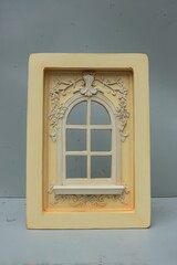 A stunning golden window frame stands out against a sleek gray wall.