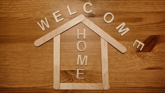 Welcome home spelled out with wood letters and animated using stop motion. With a wooden popsicle stick house.